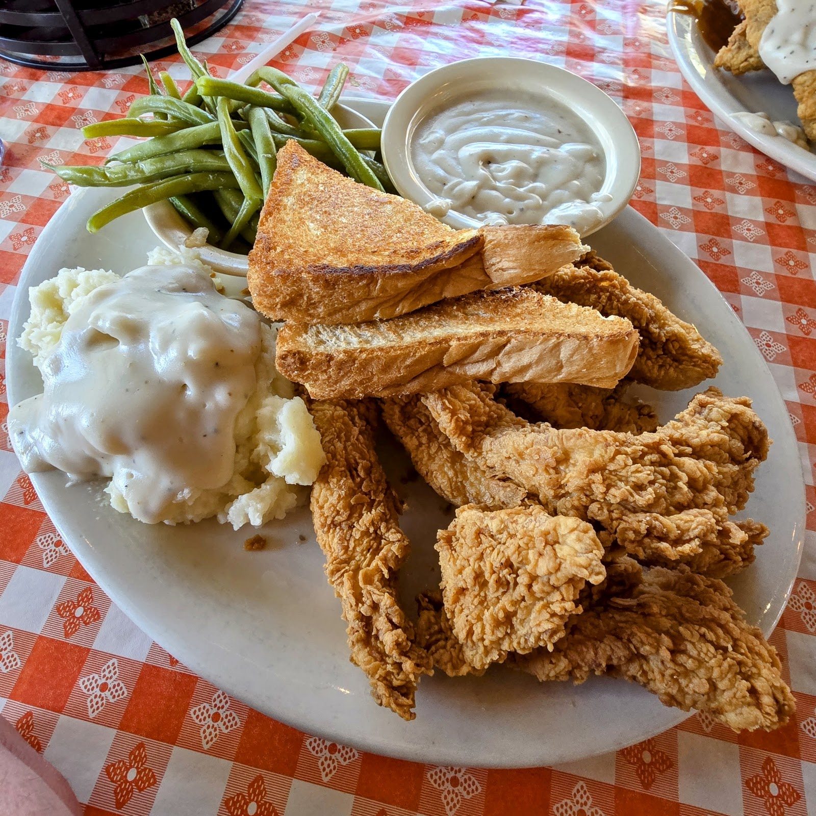 Chicken tenders with cream gravy, green beans, and toast